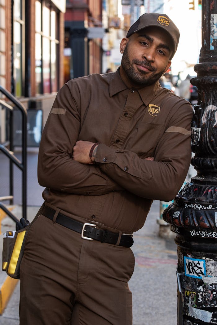 Courier in uniform posing outdoors, adding urban charm in New York City.